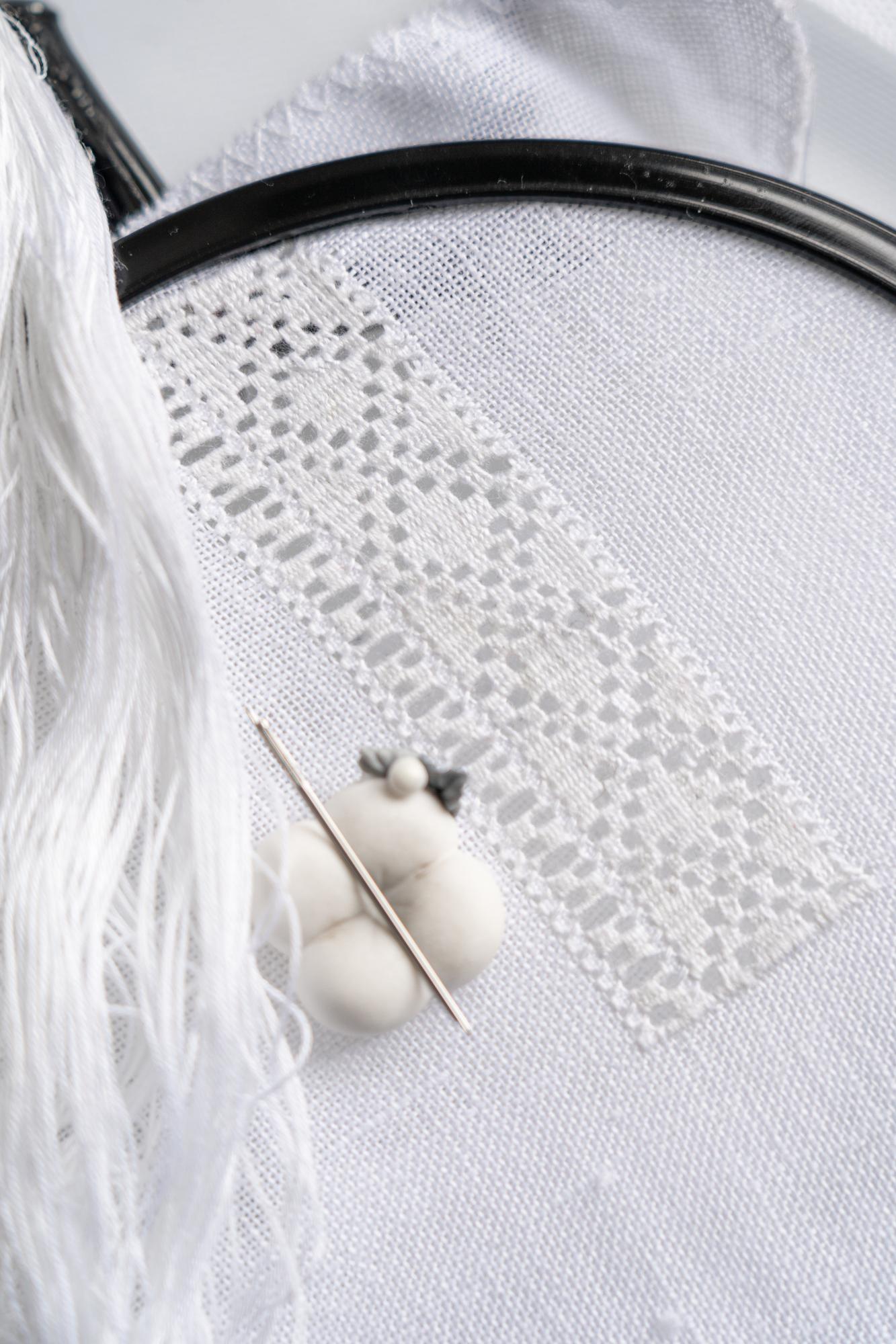 artisan stitching floral pattern on linen